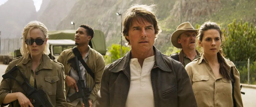 Ethan Hunt and his team walking toward the camera in rugged mountain terrain in a still from the film
