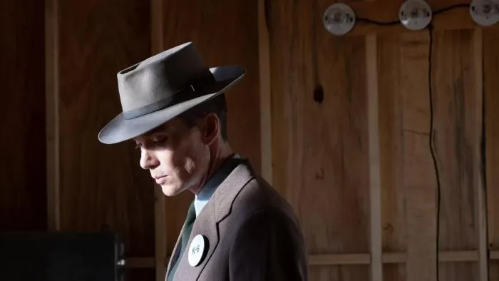 J. Robert Oppenheimer shown in profile wearing a grey fedora and suit in a still from the film