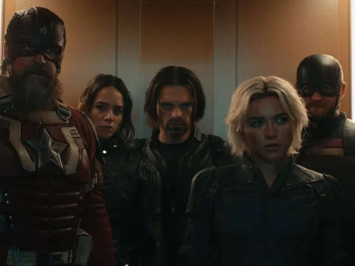 A team of armed antiheroes standing together in a dimly lit industrial space in a still from Thunderbolts